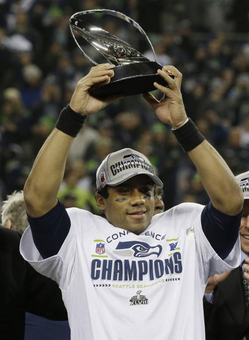 The Seahawks QB Russel Wilson holding the Super Bowl XLVIII trophy