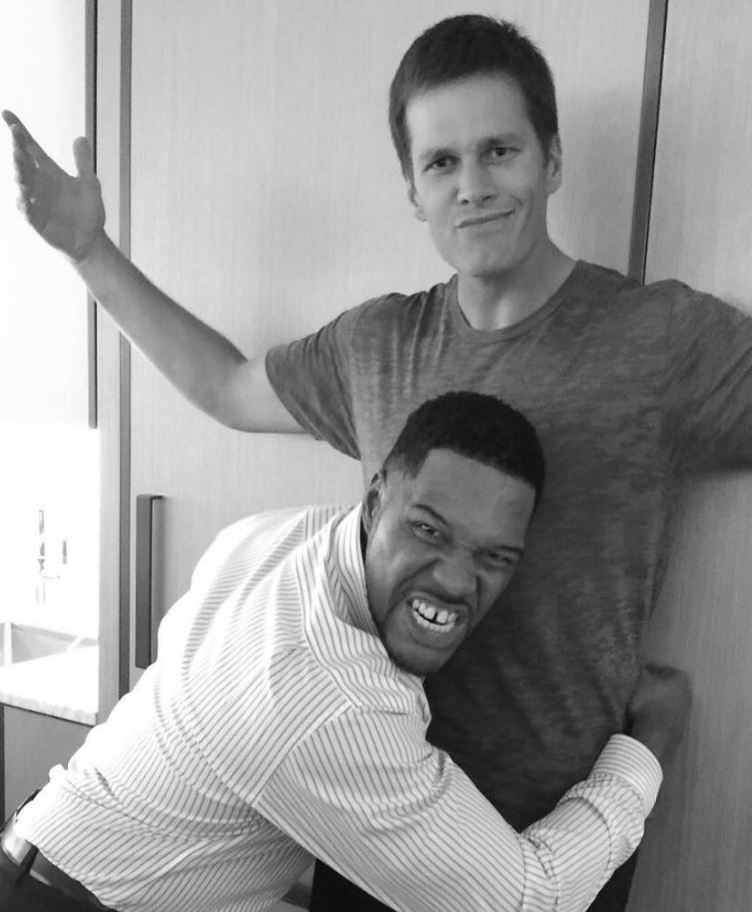 Michael Strahan having fun with Tom Brady