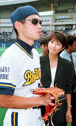 Yumiko Suzuki, right, wife of Seattle Mariners' Ichiro Suzuki and an  unidentified person, left, smile and cheer as they look on following  Ichiro's 200th hit in the second baseball game of a