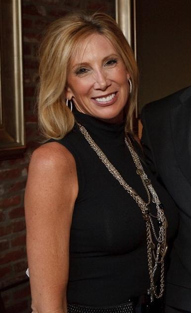 Janet Elway in a black dress smiling for the camera