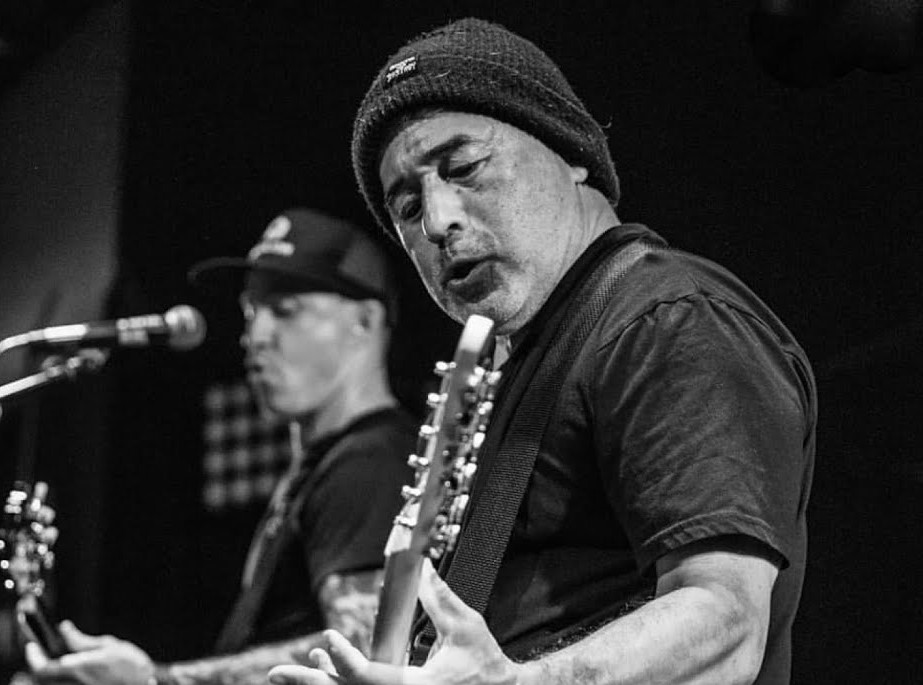 Steve Caballero playing bass guitar in a music show.