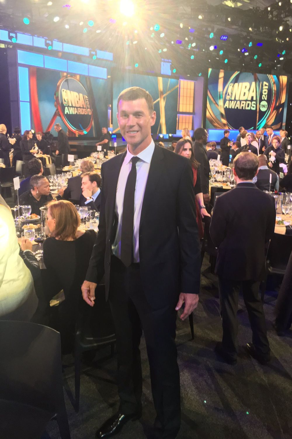 Matt Carroll Standing In A Black Suit At An Event