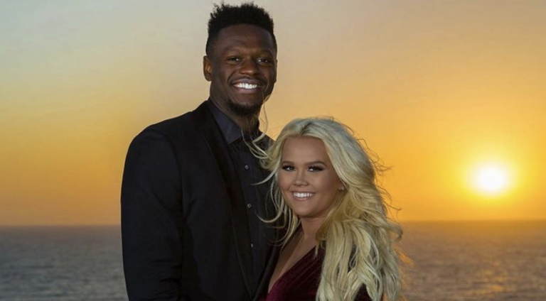 Julius Randle and his wife Kendra Shaw Randle in front of ocean and setting sun