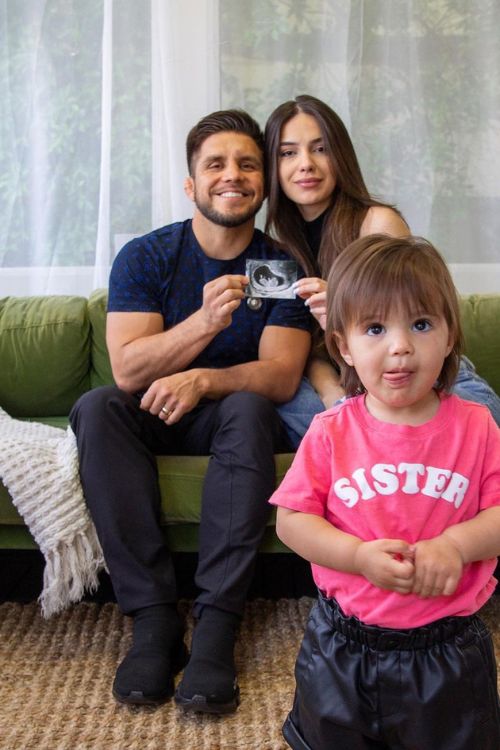 Cejudo With His Wife And Daughter Showing An Ultrasound Picture Of His Expected Baby