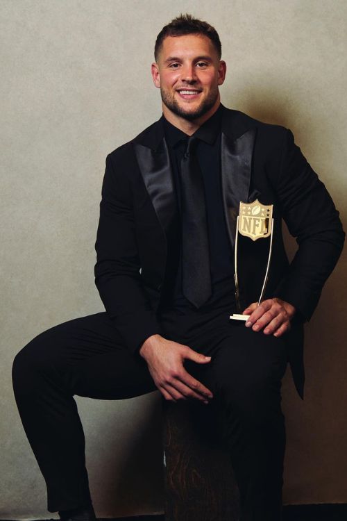 Nick Bosa Holding His 2022 NFL Defensive Player Of The Year Award