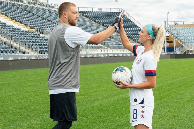 Julie Gives A High-Five To Her Husband Zach Ertz As The Two Athletes Are Pictured In A Soccer Field In 2020 