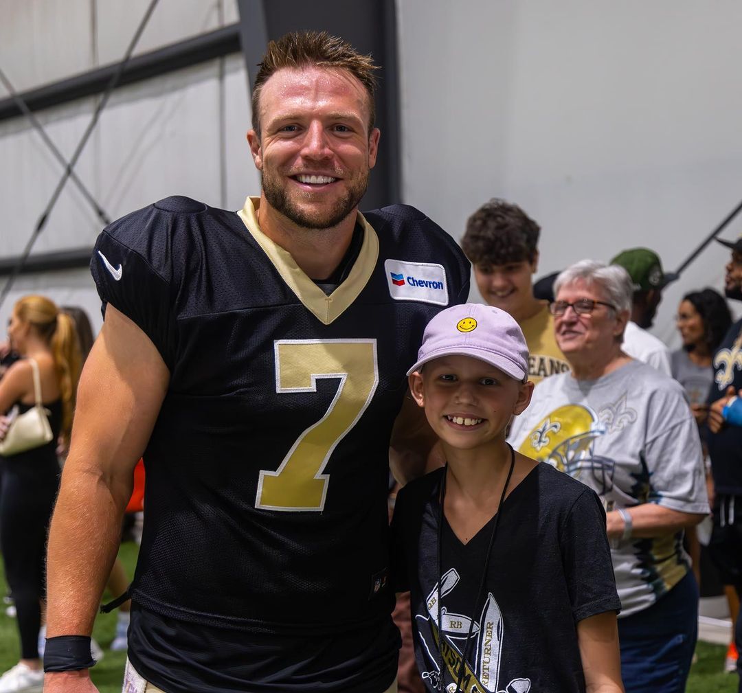 Taysom Hill Posing With A Young Fan Who Came To Visit Him