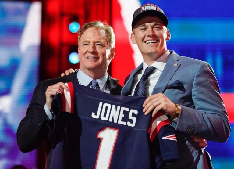Mac Jones Pictured With NFL Commissioner Roger Goodell Holding The Patriots Jersey In The 2021 NFL Draft
