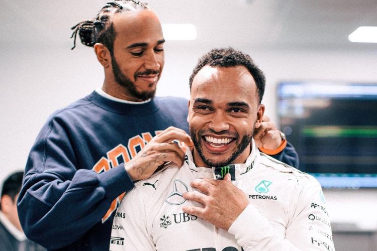 Lewis Hamilton Pictured With His Younger Half-Brother Nicolas Hamilton Last Year As He Helps Him To Wear The Mercedes Gear 
