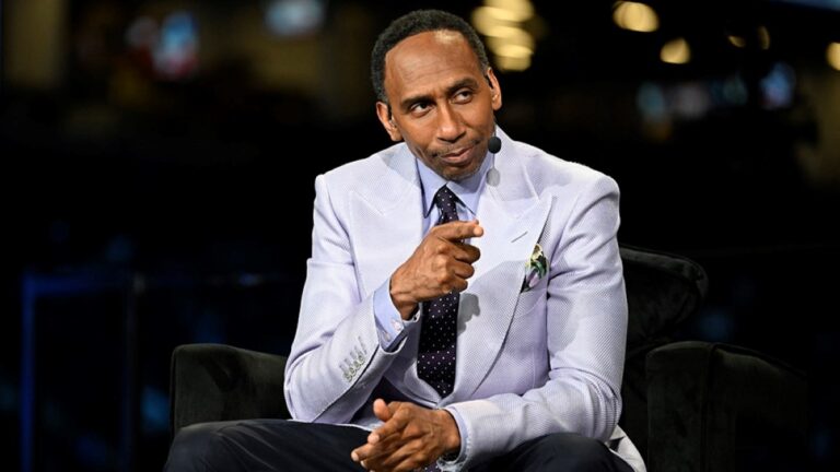 Stephen A. Smith pictured in a white suit and tie