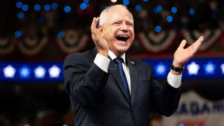 Tim Walz pictured while clapping his hands